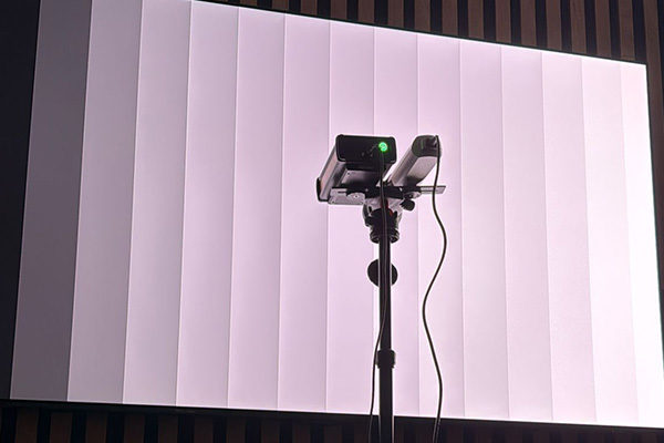 Processor calibration process being shown. Equipment on tripod recording data from a tv display.