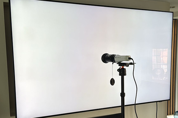 Blank tv screen with a tripod and recording equipment infant calibrating the display.